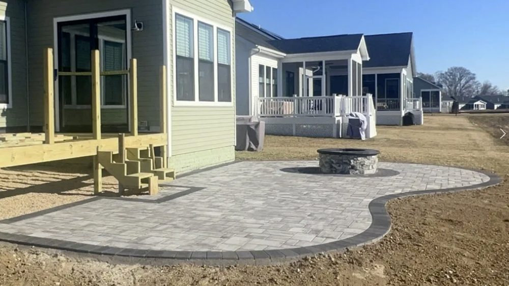 Paver patio under construction, with deck framing and steps being built